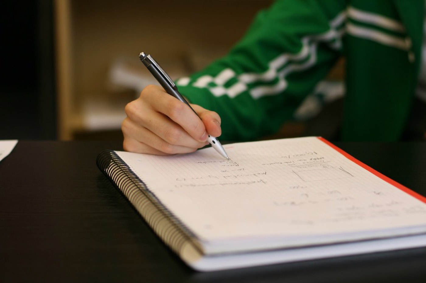 Vermieter erstellt am Schreibtisch mit Unterlagen und Rechner eine Nebenkostenabrechnung